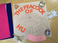 Fabric letters reading ‘The Peacock of Humility’ laid out on a template with an illustration of a peacock, the image includes letter stencils, pencils and scissors.