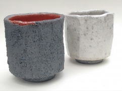 An image of two small pots, one in dark speckled grey and one in light.