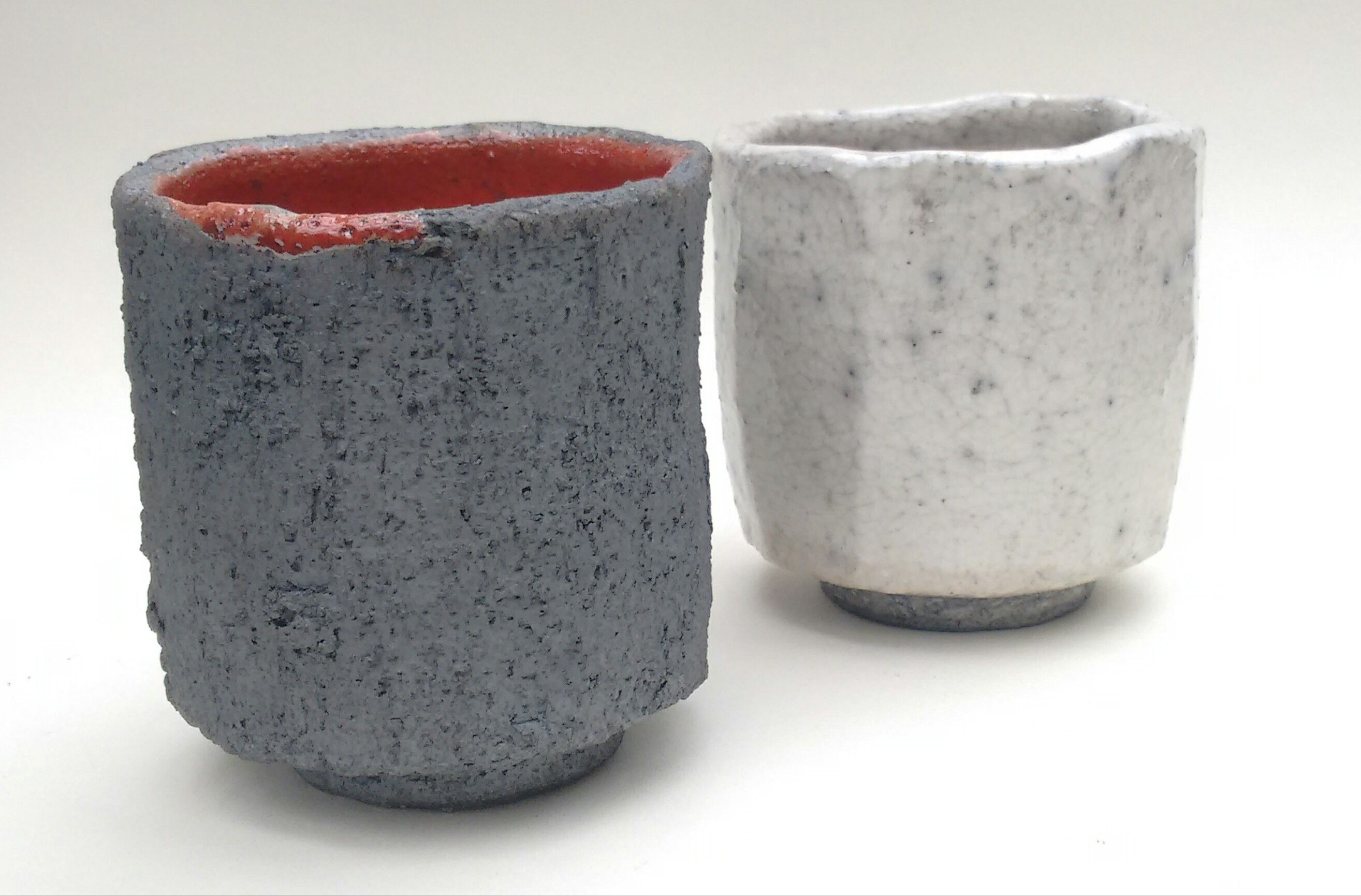 An image of two small pots, one in dark speckled grey and one in light 