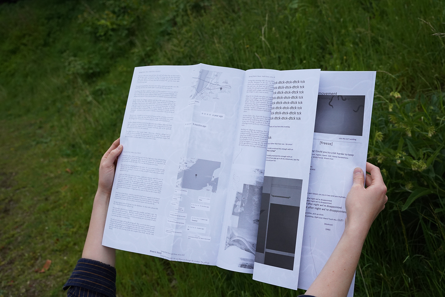 Hands opening a copy of the Infection publication, a white and grey folded A3 sheet of paper. The background is a meadow.